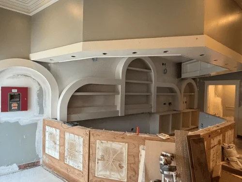 Bar wall with arched shelving niches formed and finished, the curved bar front still in plywood