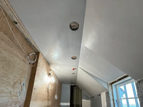 The same attic room after plastering, sloped ceiling and dormer wall finished smooth
