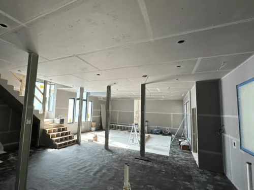 Basement ceiling and walls in blueboard with taped seams and steel columns boxed in