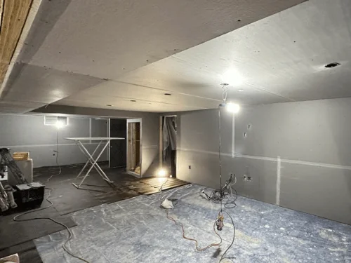 Basement with a boxed soffit and walls in blueboard, taped and ready for plaster