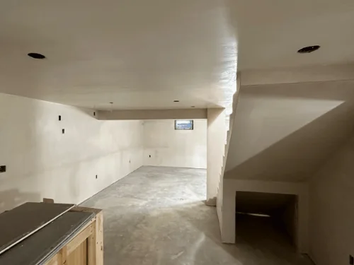 Basement after plastering, smooth walls running back to a small window