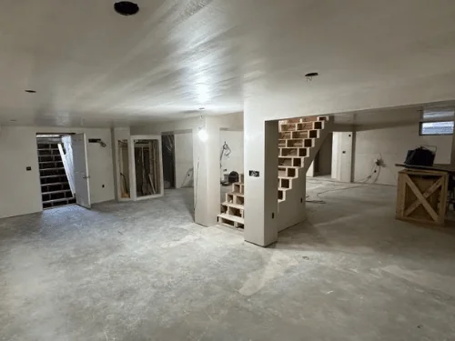 Plastered basement with the main stair wrapped in board and the bulkhead door open