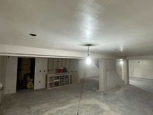 Long basement with a plastered beam soffit and a built-in framed along the wall