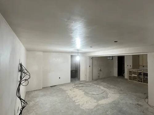 Basement room in fresh plaster with a soffit and wiring left out for the electrician