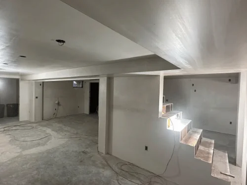 Basement with a plastered soffit and an open stair with a stepped side wall