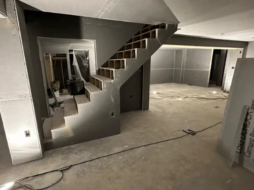 Open basement stair framed in with blueboard, joints taped and corners beaded