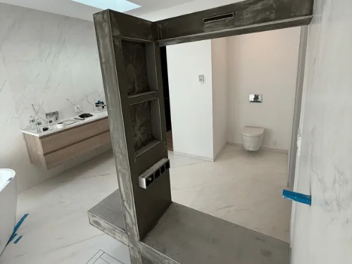 Gray troweled plaster on a bathroom bench and shelf frame with a built-in niche