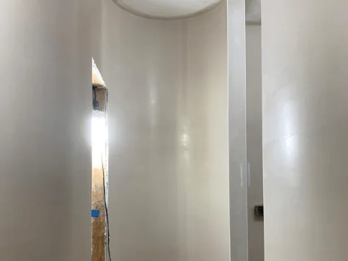 Hallway with curved plaster walls and a rounded ceiling edge