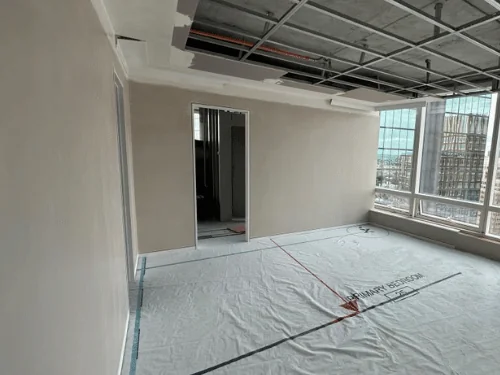 Plastered bedroom walls with a doorway and the steel ceiling grid still exposed