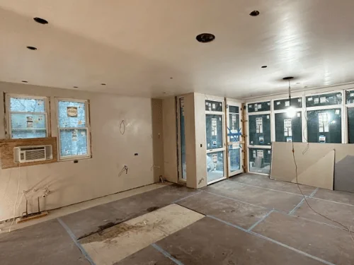 Corner of new windows and fresh plaster walls, floor protection taped down
