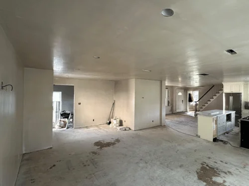 Open kitchen and living area after plastering, walls and ceiling smooth and ready for paint