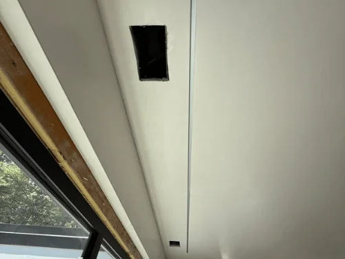 White plaster ceiling with a narrow recessed reveal and an opening for a light fixture