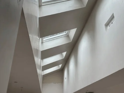 Row of skylights set in deep plastered wells above angled walls