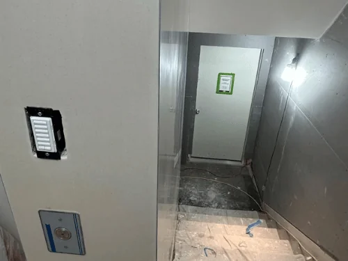 Stairwell with plastered walls leading down to a basement door