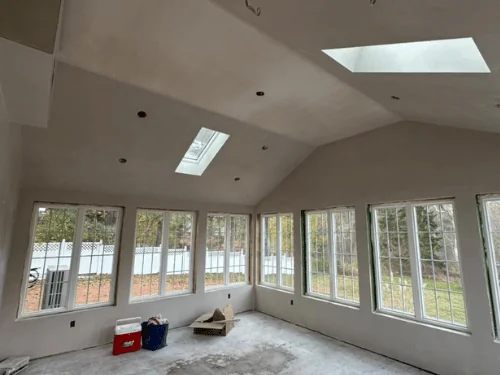 Sunroom walls and vaulted ceiling in fresh plaster between rows of windows