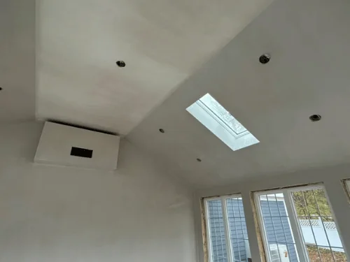 Vaulted ceiling with a skylight and a boxed chase, all finished in smooth plaster